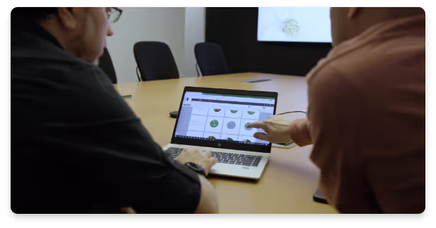Two men pointing at the laptop in an office
